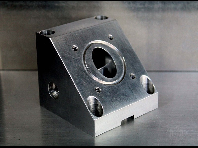 Side view of triangular machined part with hole in the center